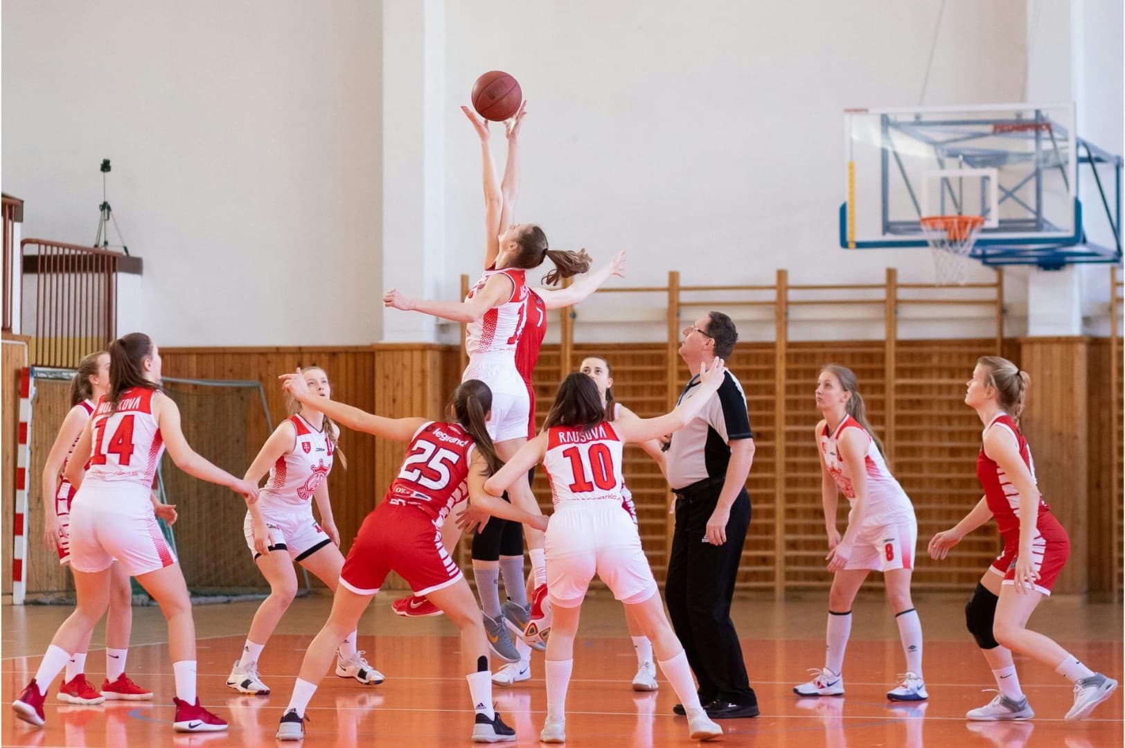 Girls basketball jump ball at the start of a game