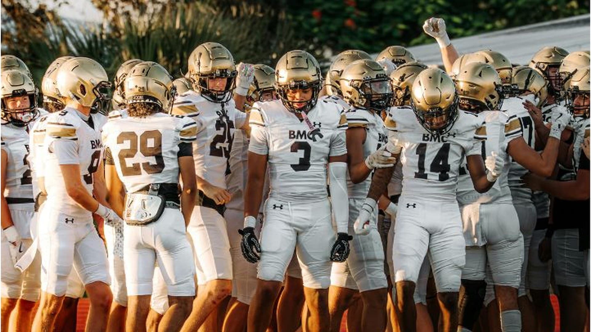 High school football team gathered under the goalpost at golden hour