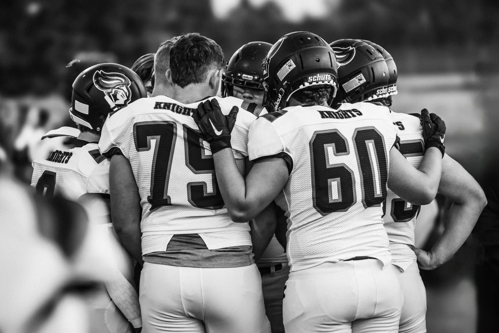 Football team gathered in a huddle before the play