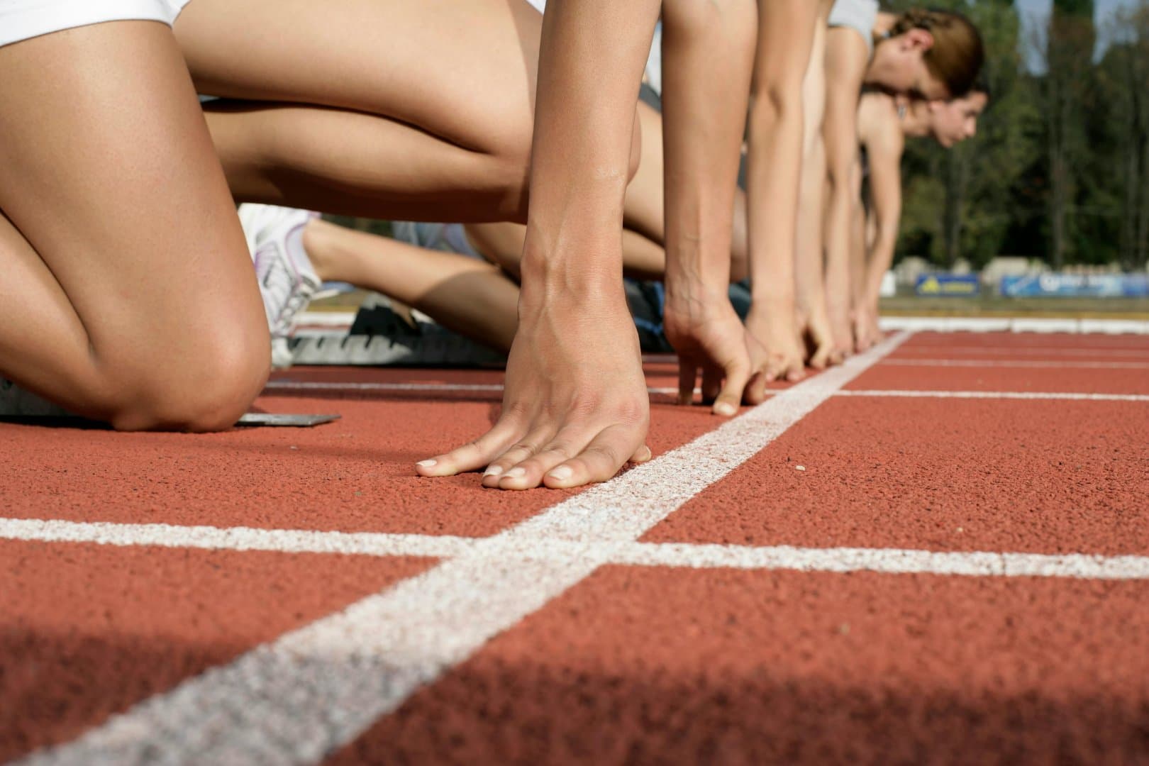 Sprinters set in the starting blocks ready to push off the line
